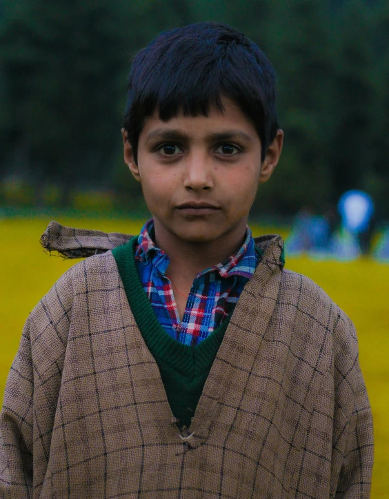 a boy is posing with a stuffed animal in his jacket