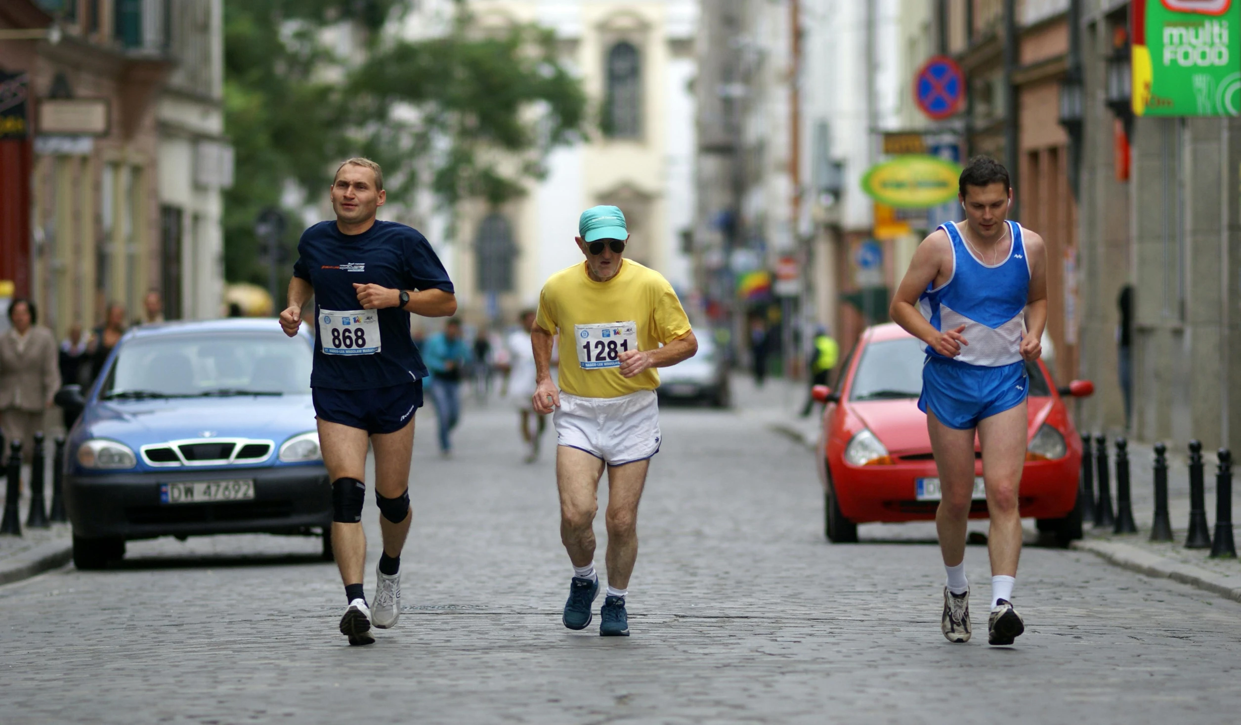 a couple of men running down a city street