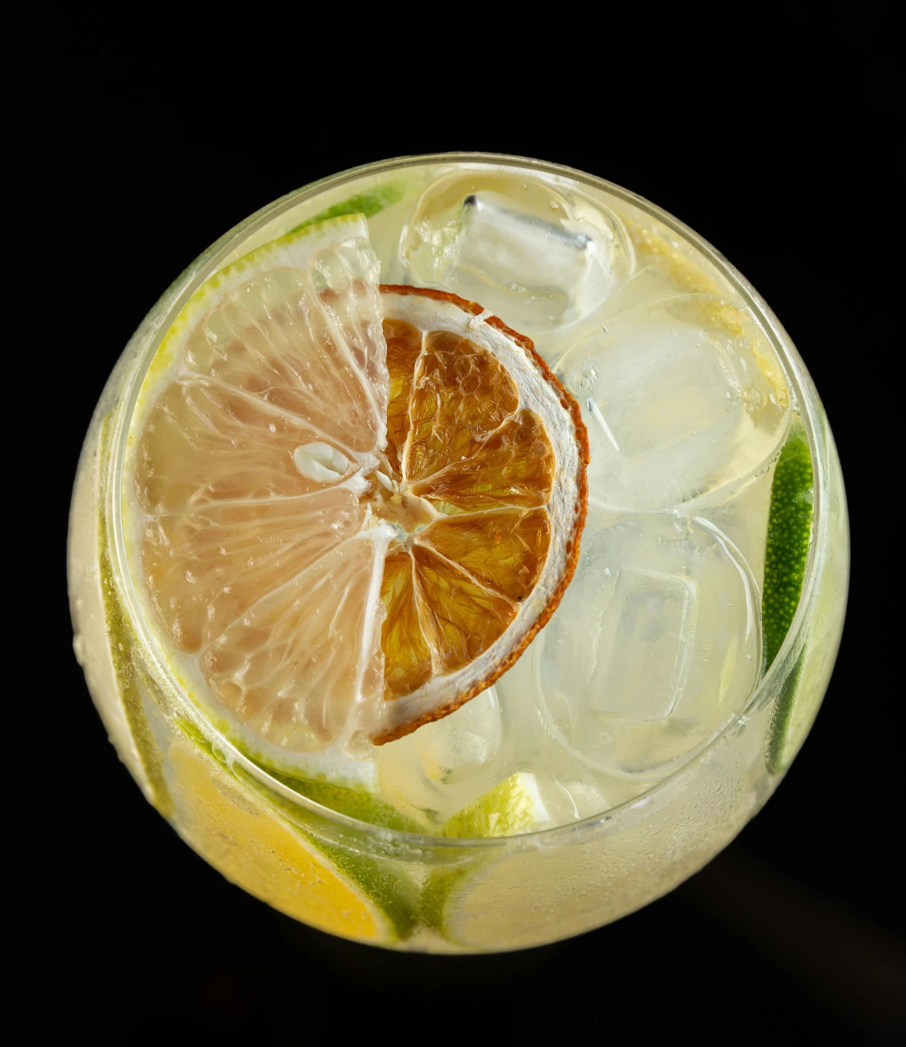 a glass with a drink that contains orange, lemon and lime