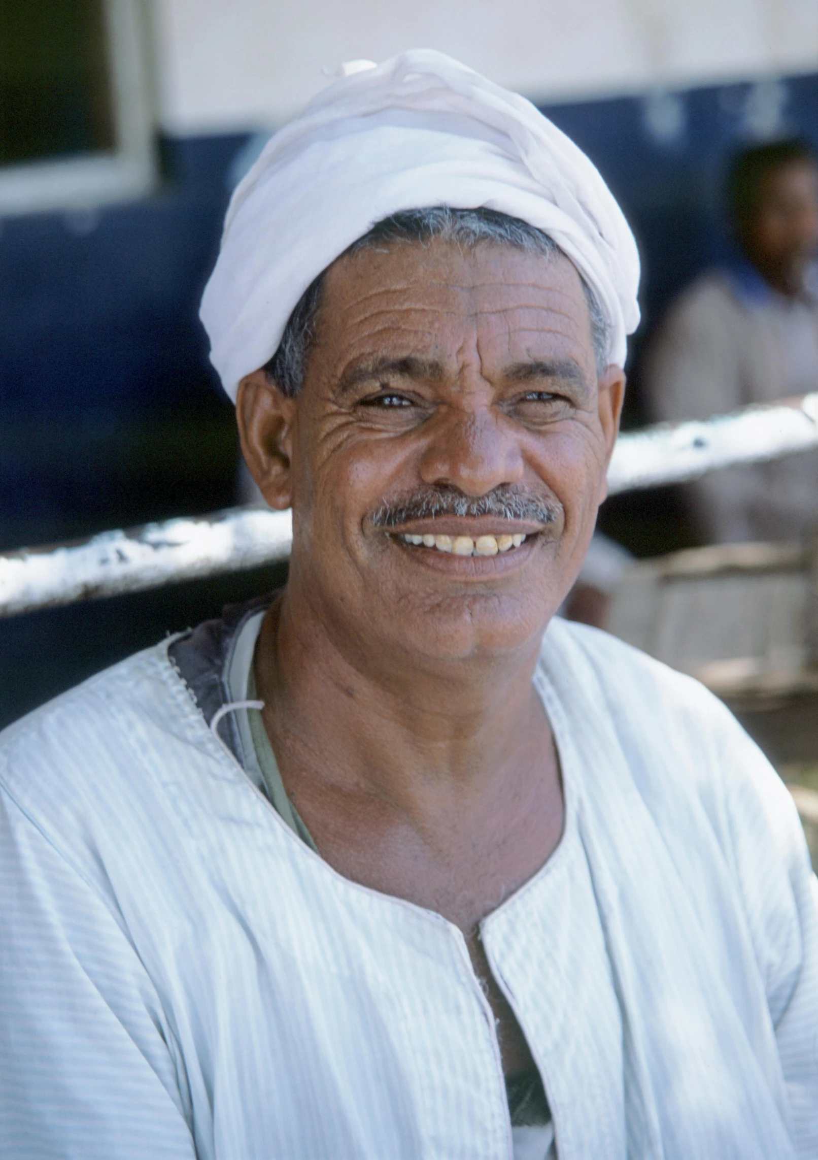a man in white is smiling at the camera