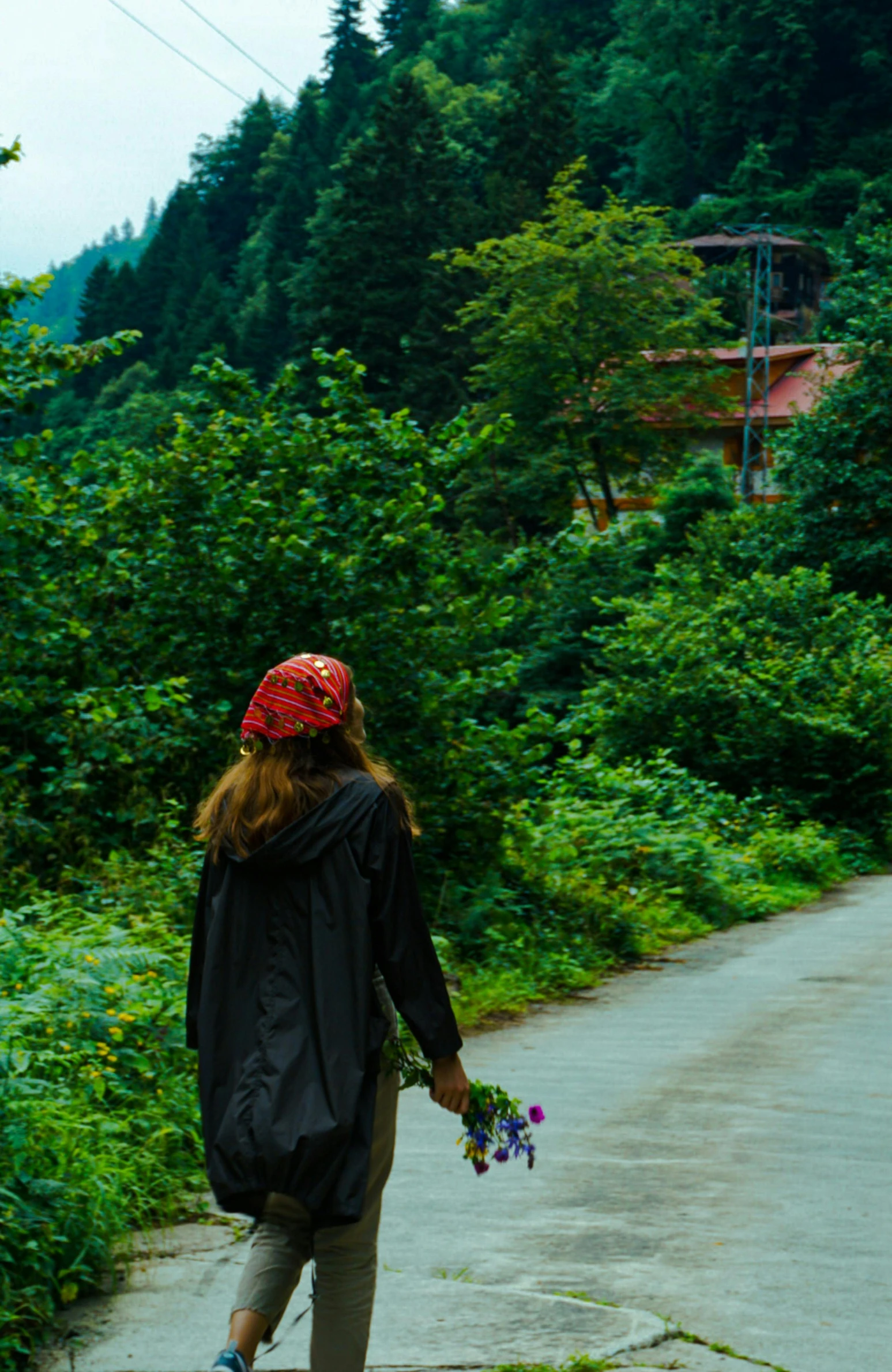 a woman in a red hat walking down a path