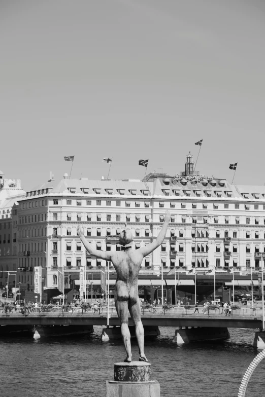 a black and white po of a statue next to the ocean