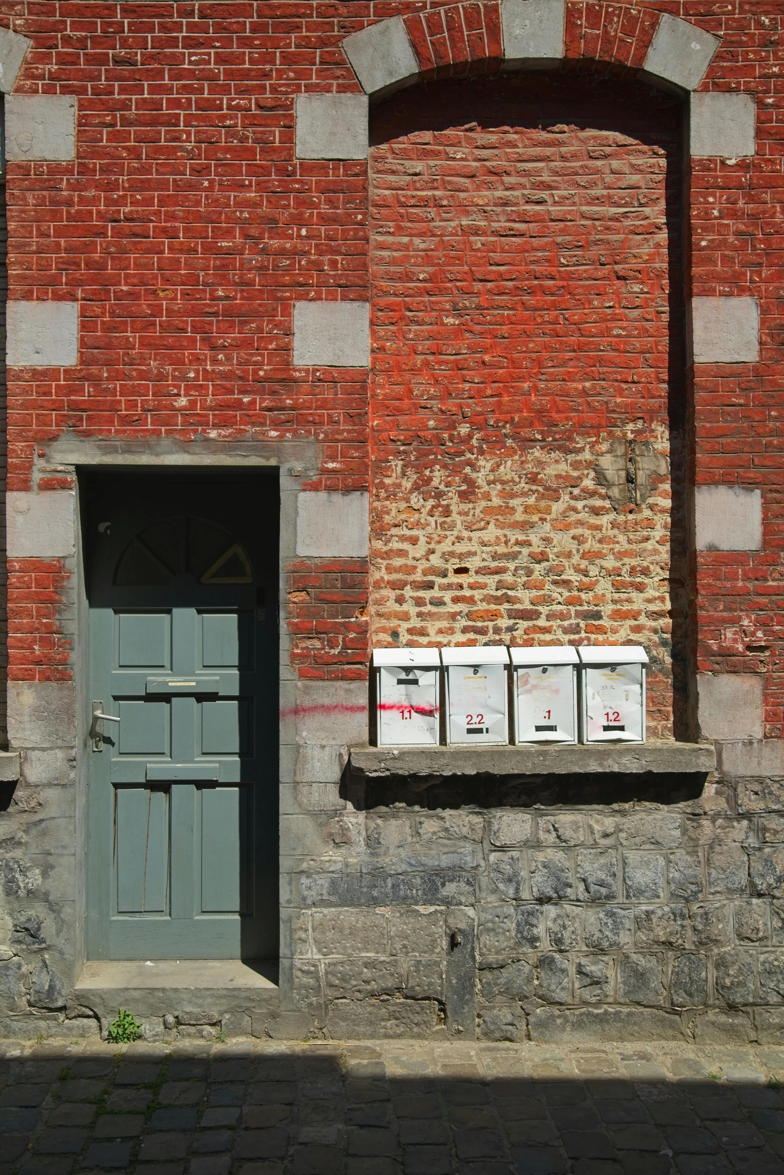 two brown door on red brick wall with white box on top