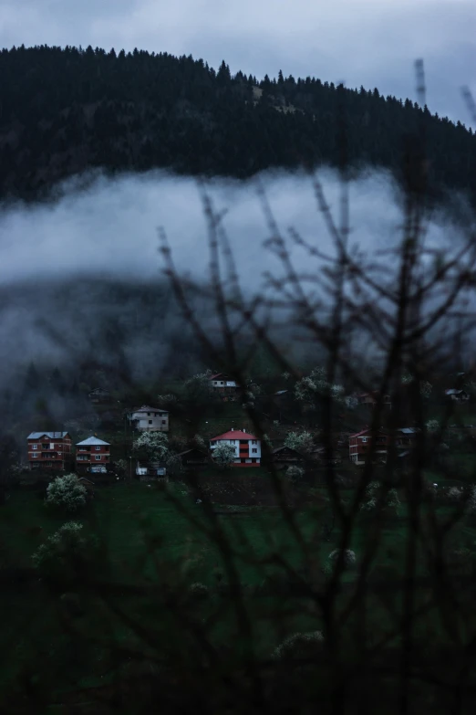 a picture taken from a hill of buildings and fog