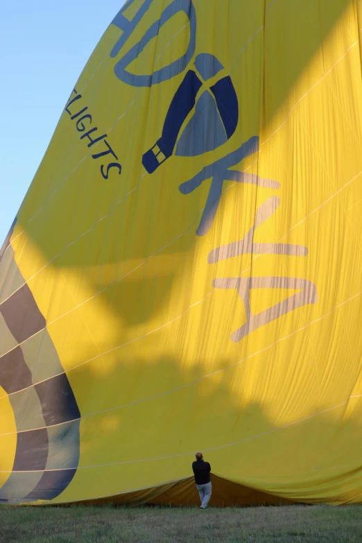 two people standing near a large yellow kite