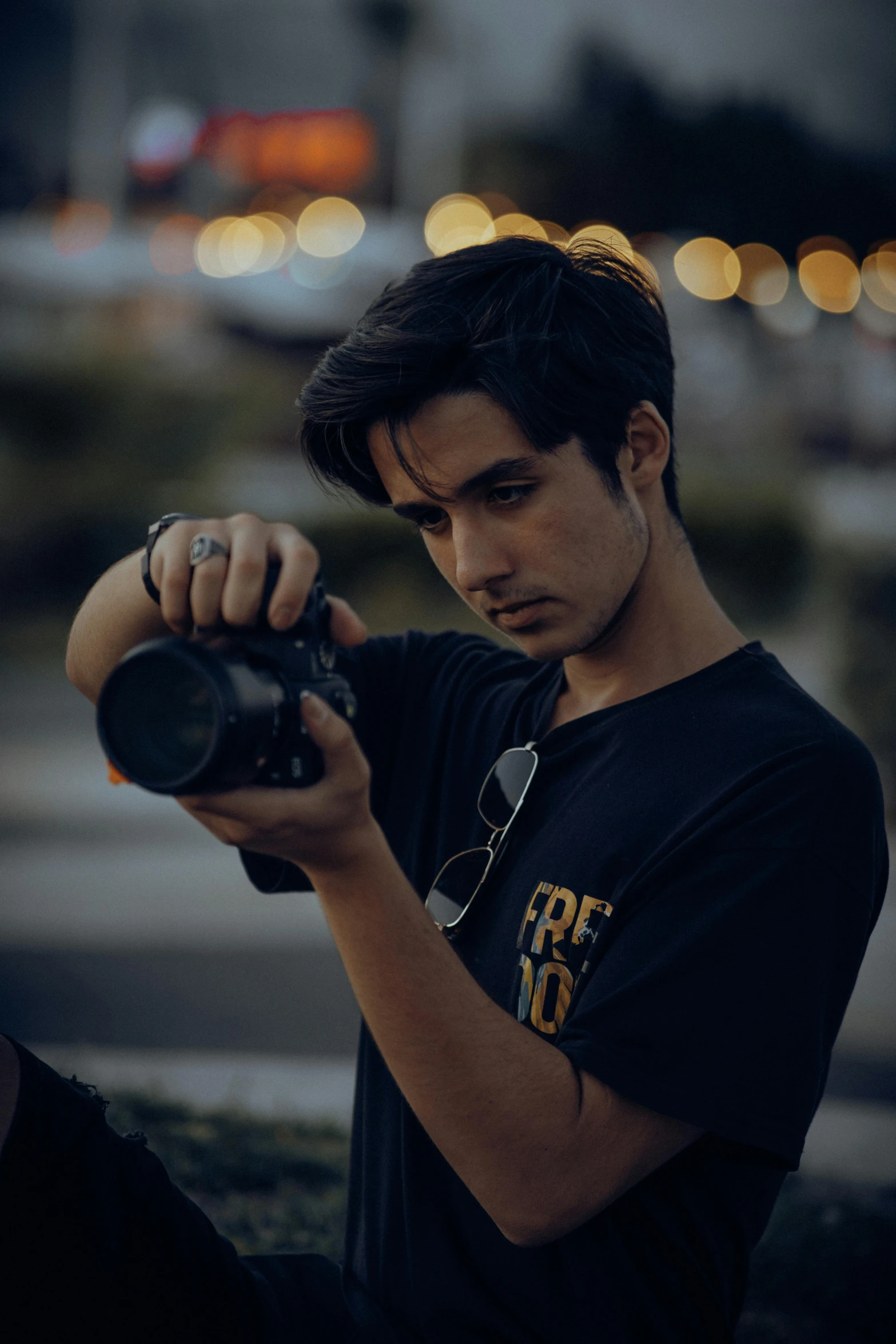 a man holding a camera in a dark street