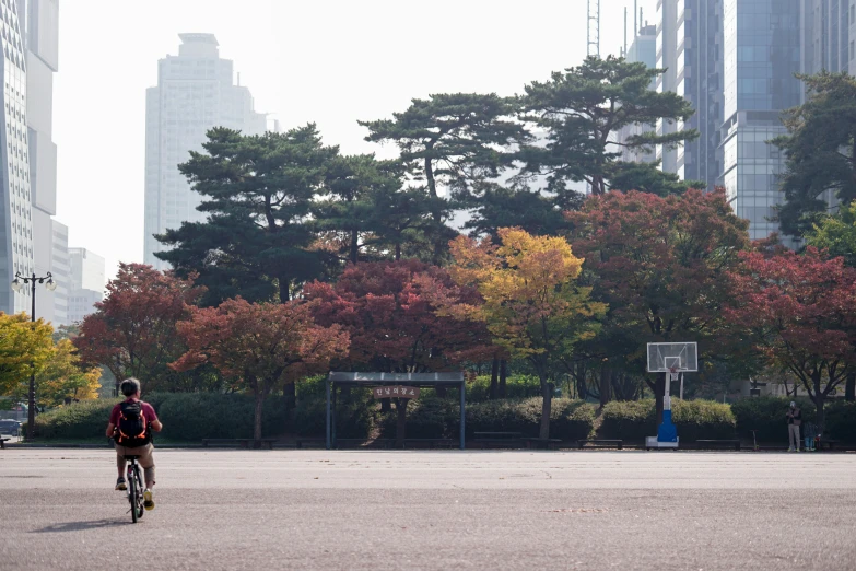 a person riding a bike in front of tall buildings