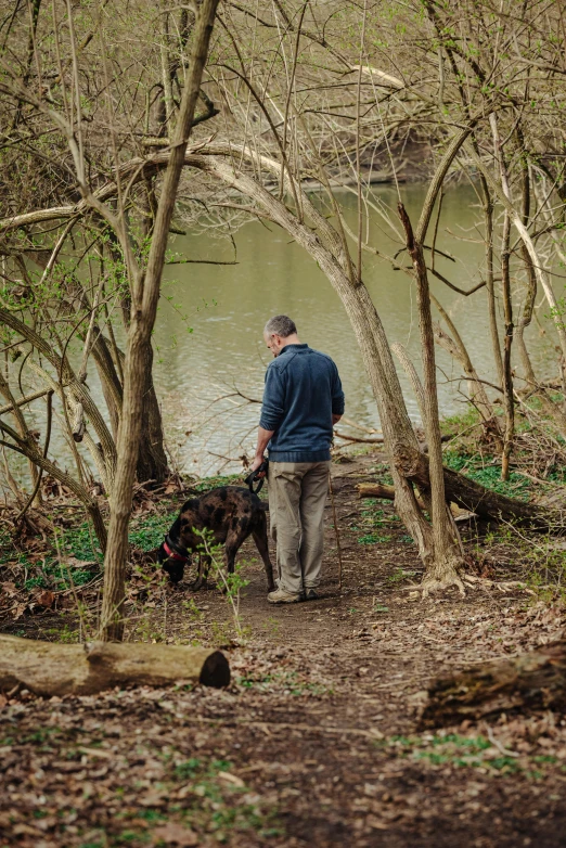 a man that is walking with some dogs in his hand