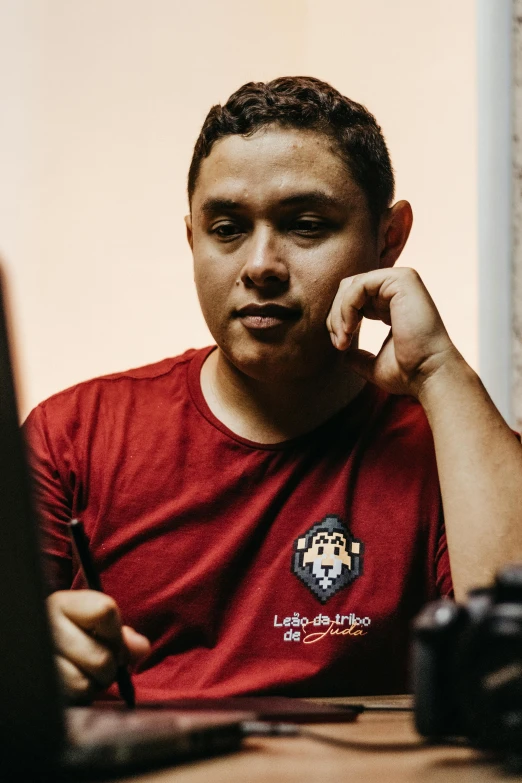 a man sitting in front of a computer while talking on a cell phone