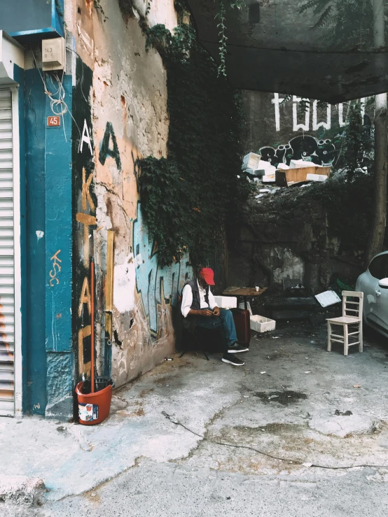 two men sitting under a covered, run down, old road