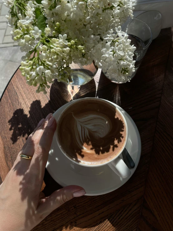 a person holding coffee in front of a table