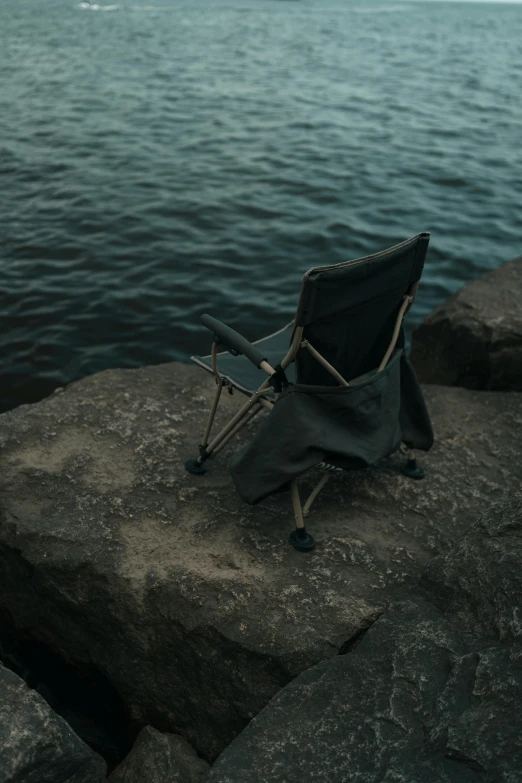 a chair on a rock over looking the ocean