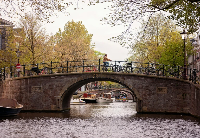 there is a bridge over the water and two boats are on the side