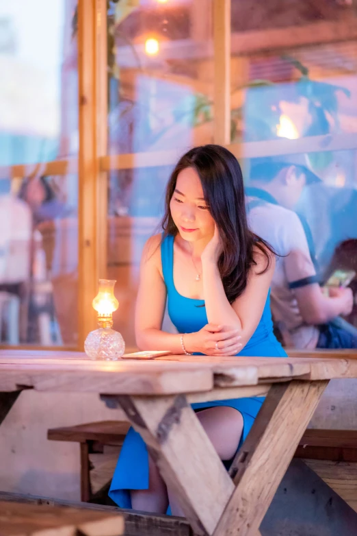 a girl in blue dress looking at her cell phone