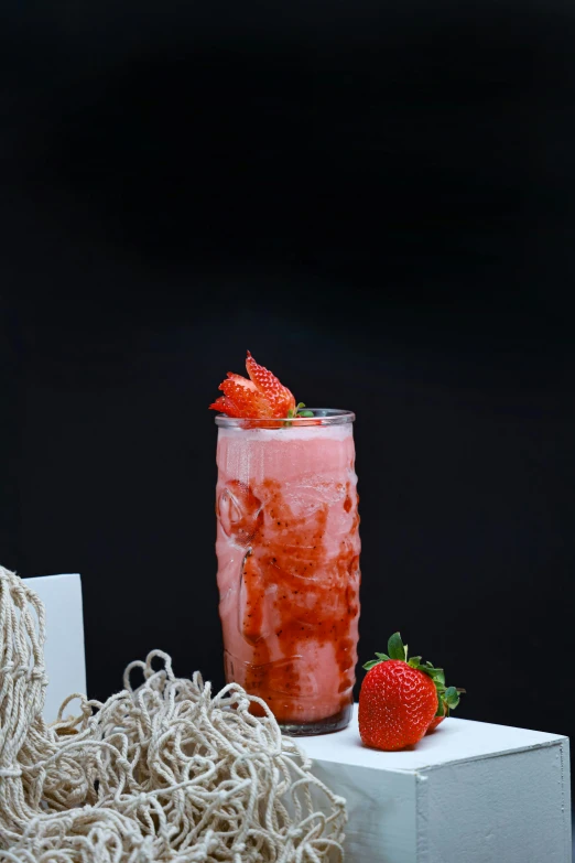 a mason jar is full of strawberries next to some pasta