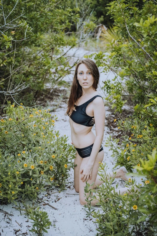 a woman wearing a bikini walking into a forest