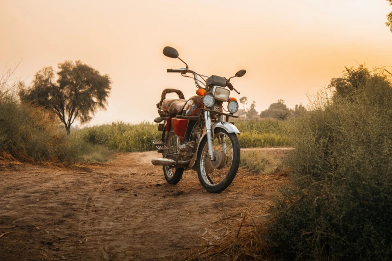 a motorcycle is parked on the road in a field