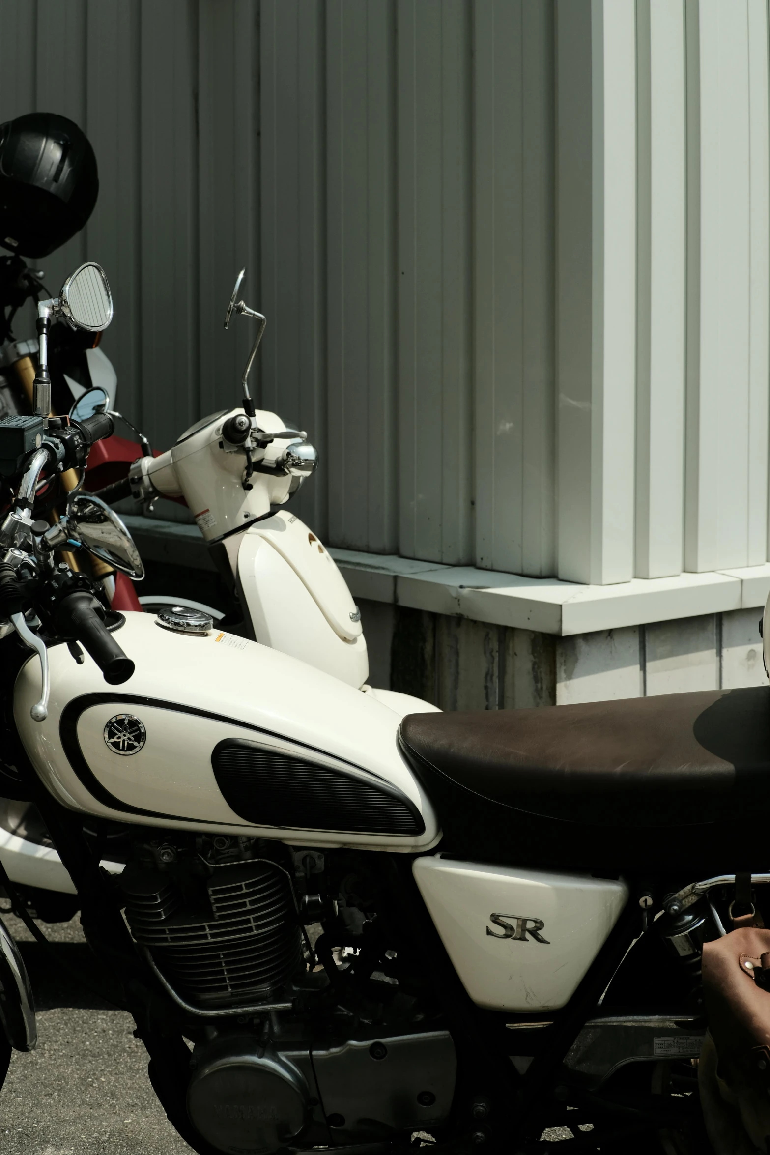 a parked motorcycle next to a building on the side of a road