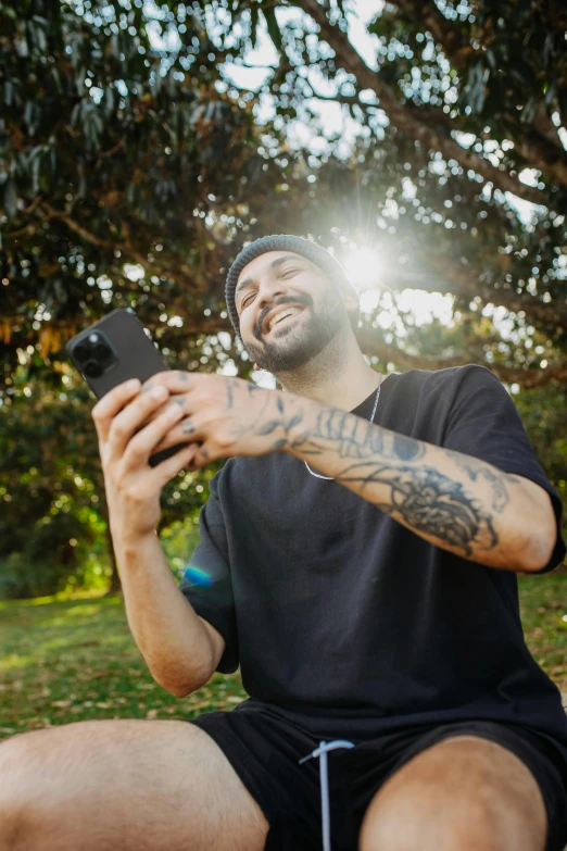 a man sitting in the grass taking a selfie