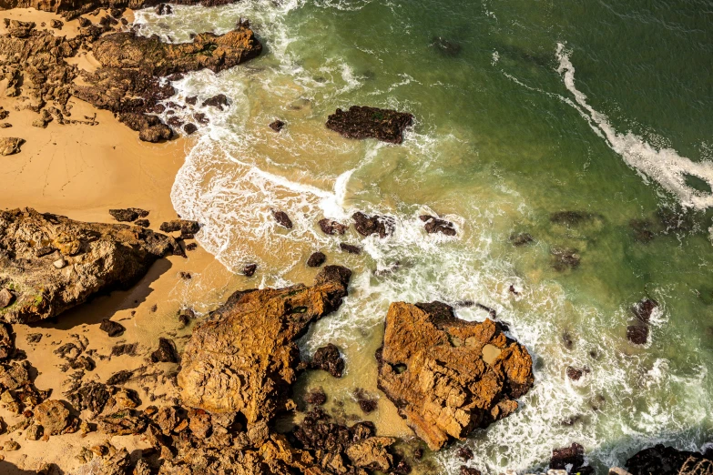 an aerial view of the coast with rocky cliffs and turquoise ocean