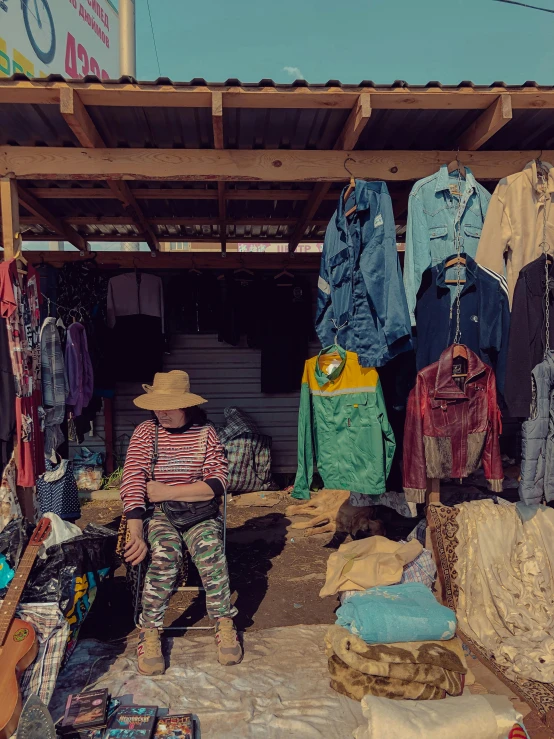 the woman is kneeling near a display of clothing