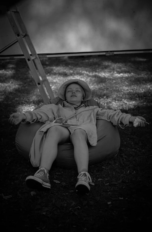 a child wearing boots and an umbrella is sitting in the grass