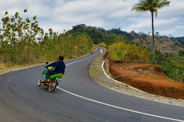 man riding a motor bike on a curving road