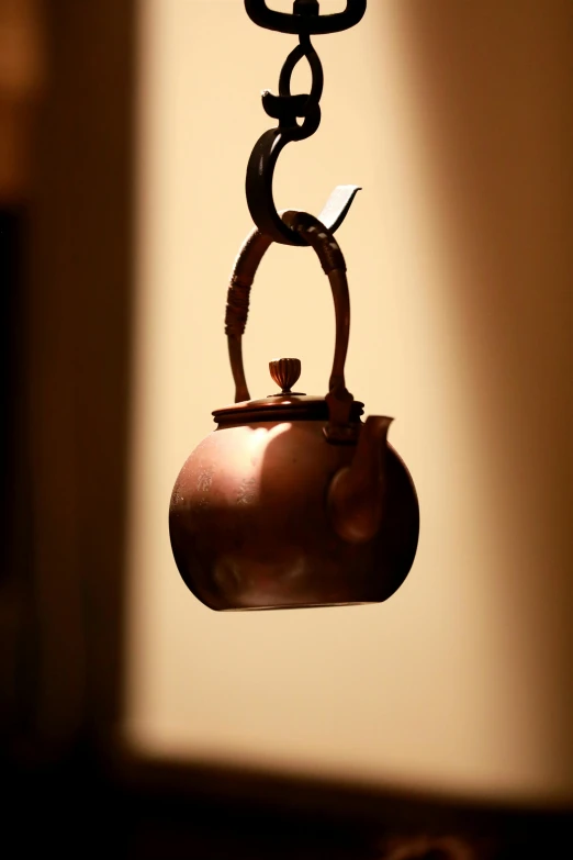 a small tea kettle suspended from a hanging beam