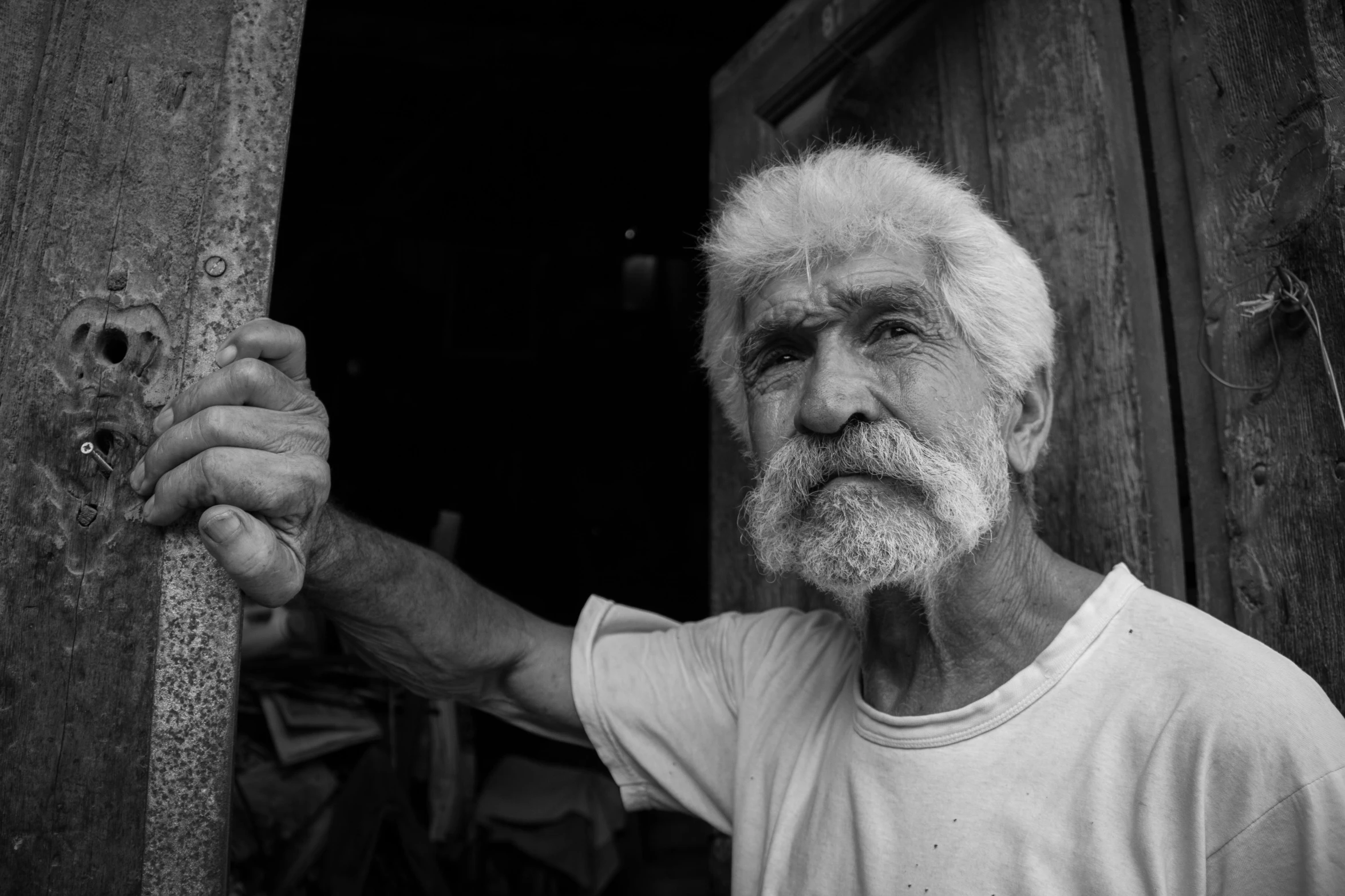 an old man with white beard wearing a white t - shirt