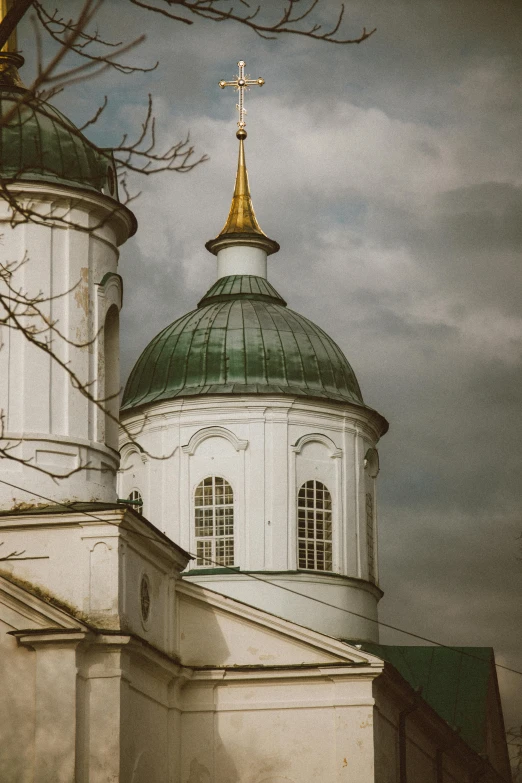 a large white building with a gold and green dome