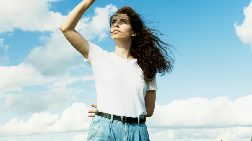 a young woman tossing a yellow frisbee on the beach