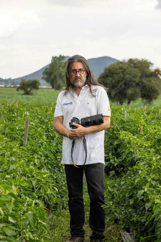 a man standing in a field with a camera
