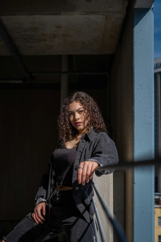 woman dressed in dark clothes leaning on the rails of a porch