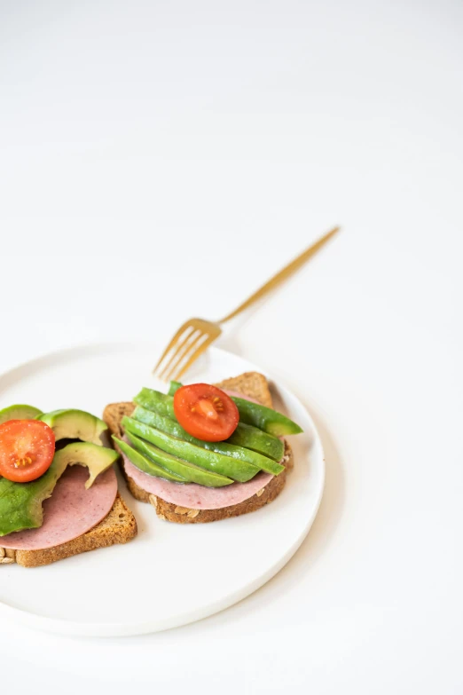 a sandwich with ham, lettuce and tomatoes