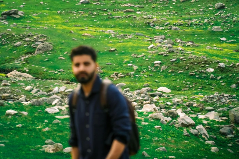 a man standing in front of a rocky field