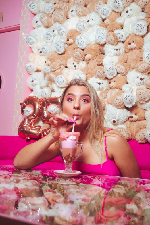 a pretty young lady drinking some drinks from a straw