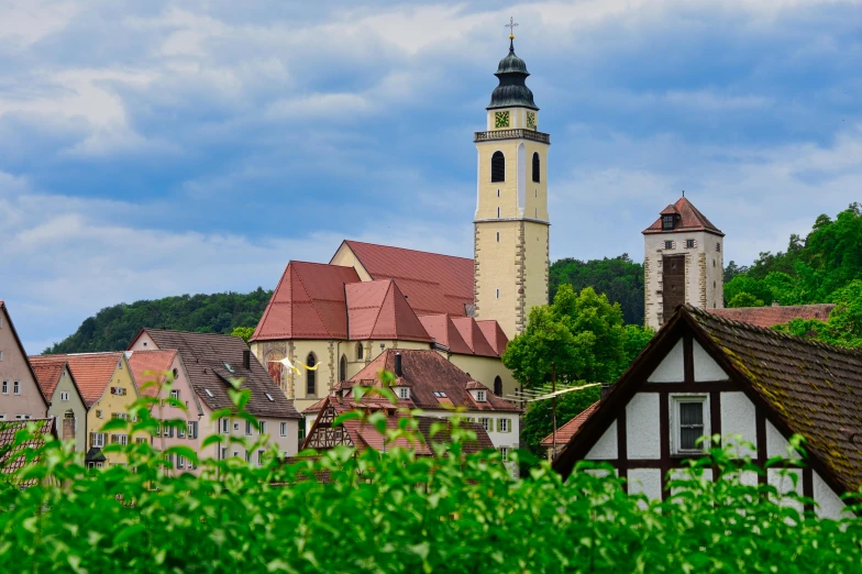 an old european city is nestled amongst lush green leaves