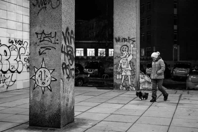 a person walking on a sidewalk with a dog