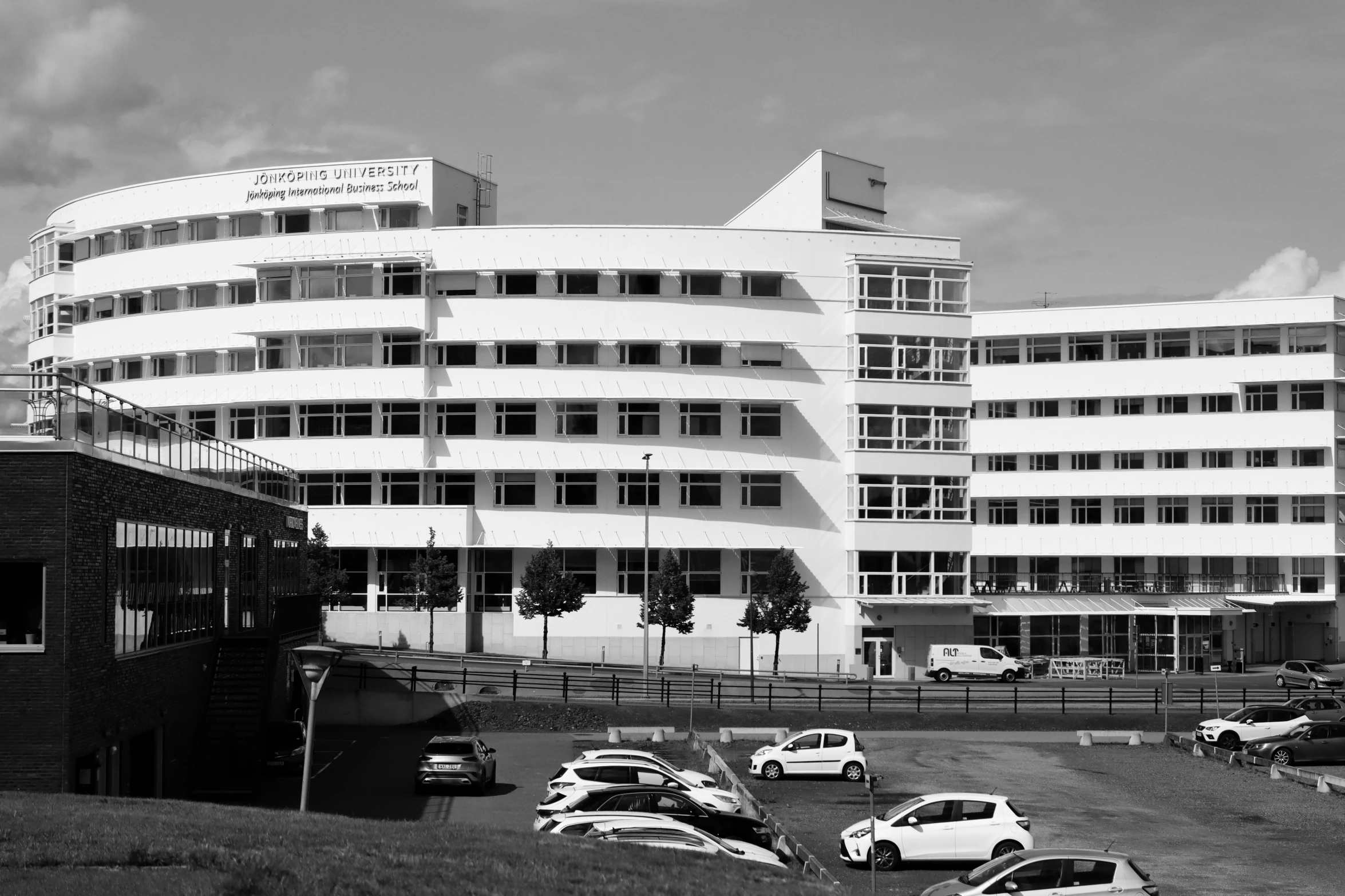 an old pograph of a building next to parked cars