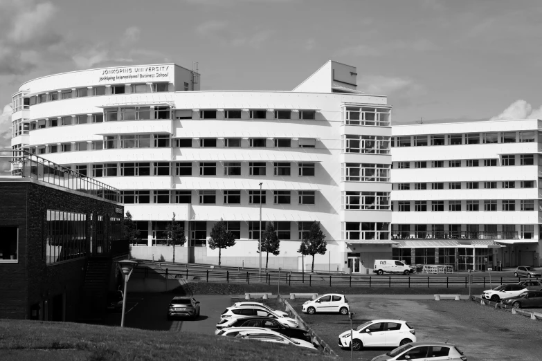 an old pograph of a building next to parked cars