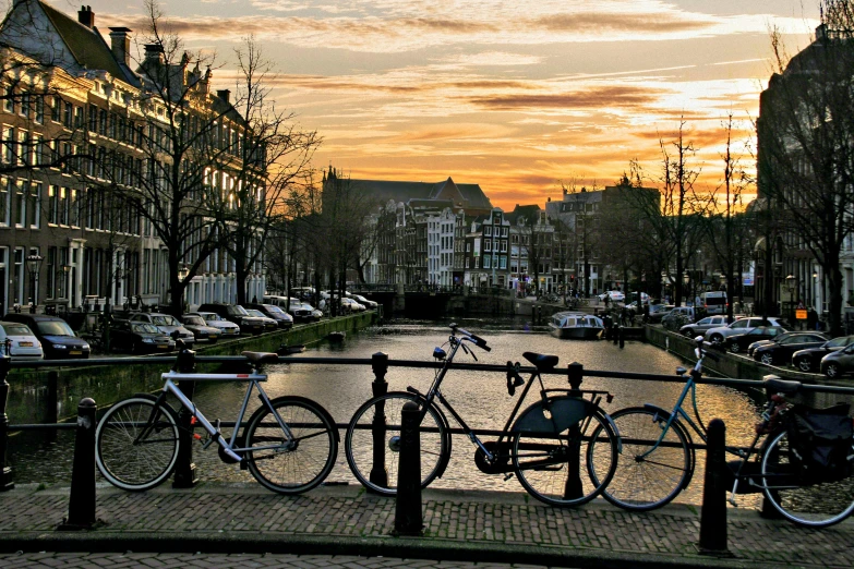 two bikes  to metal poles with a sunset background