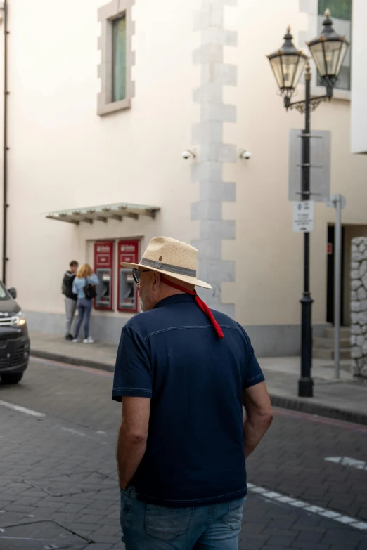 a man wearing a blue shirt and hat is walking