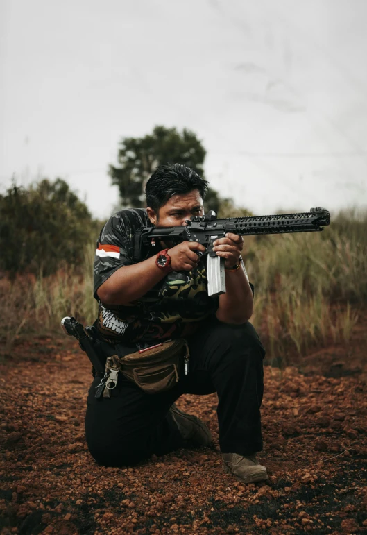 a person in camouflage shooting an akm machine