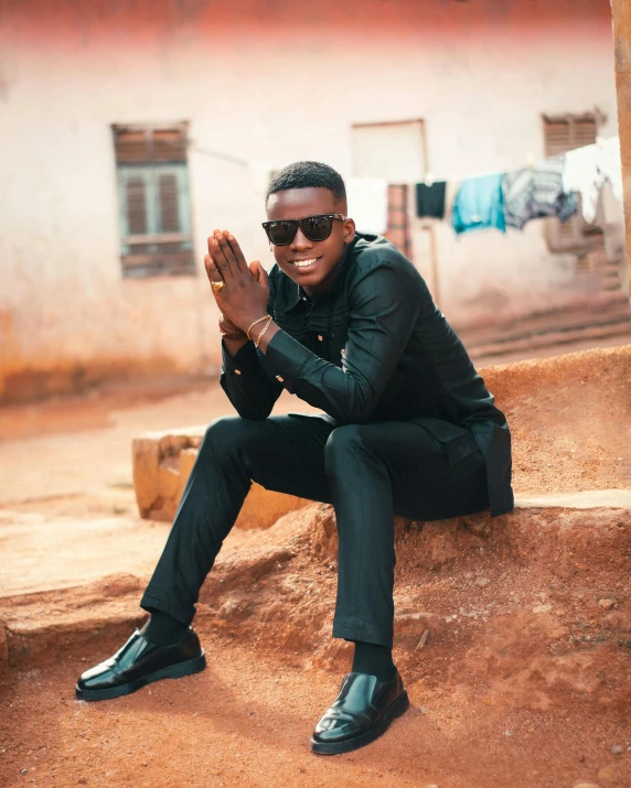 a man in dark colored clothes sitting on some rocks