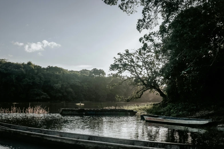 canoes sitting on the edge of a river at sundown