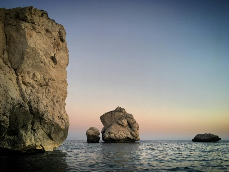 two rocks sit in the water near an ocean