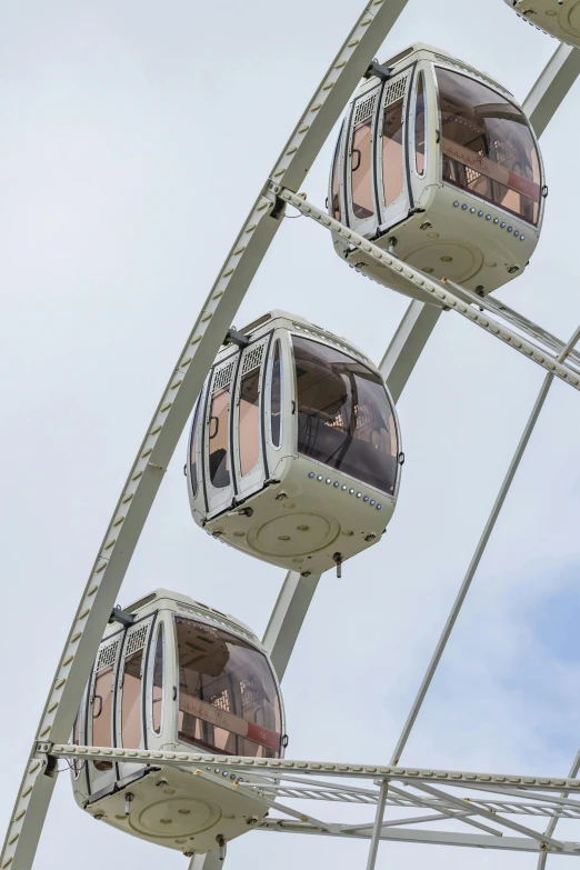 three gondola cars riding in the sky with other rides