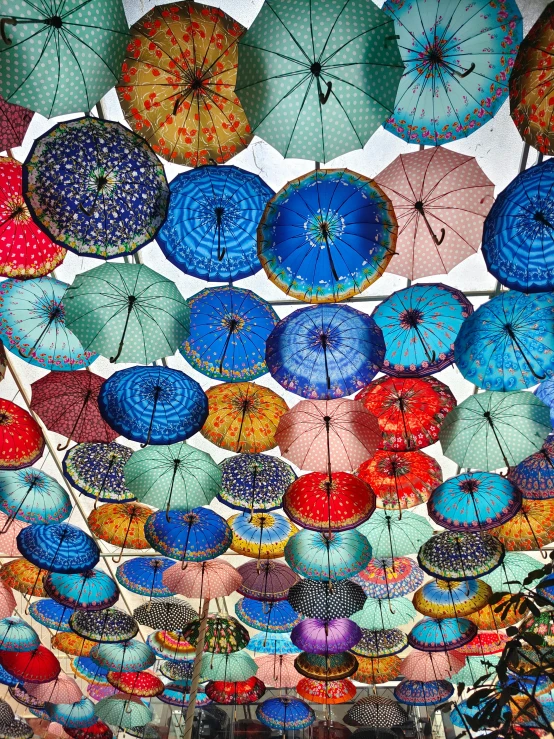 a ceiling with multiple color umbrellas hanging from it