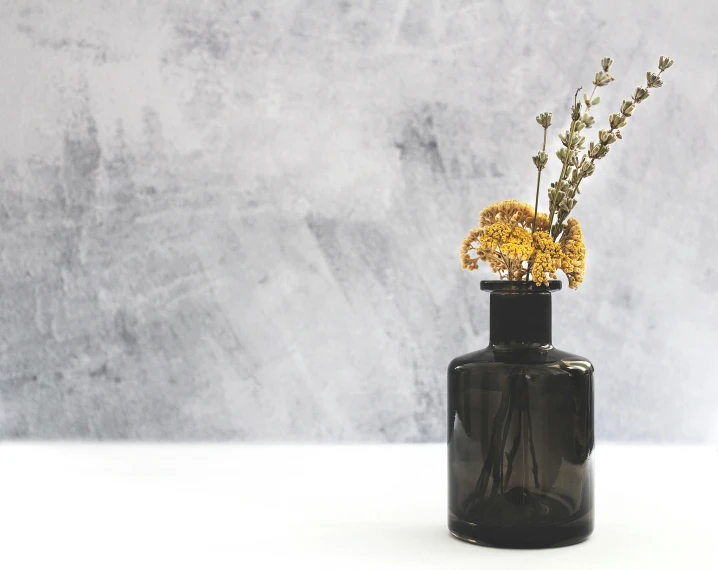 a glass vase with a couple of small yellow flowers in it