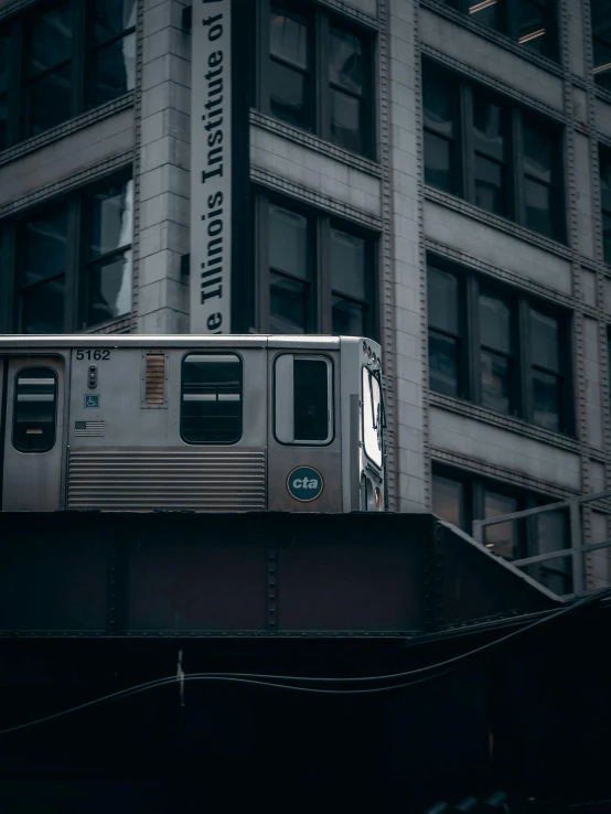 the train is traveling down the elevated road near buildings